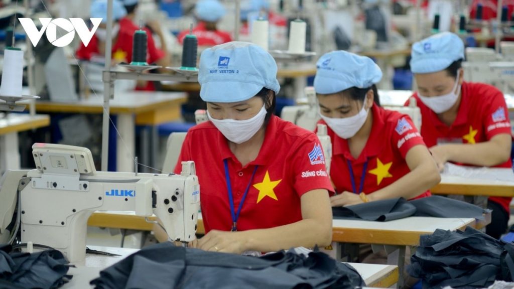 three garment workers are sewing clothes in a Vietnamese factory