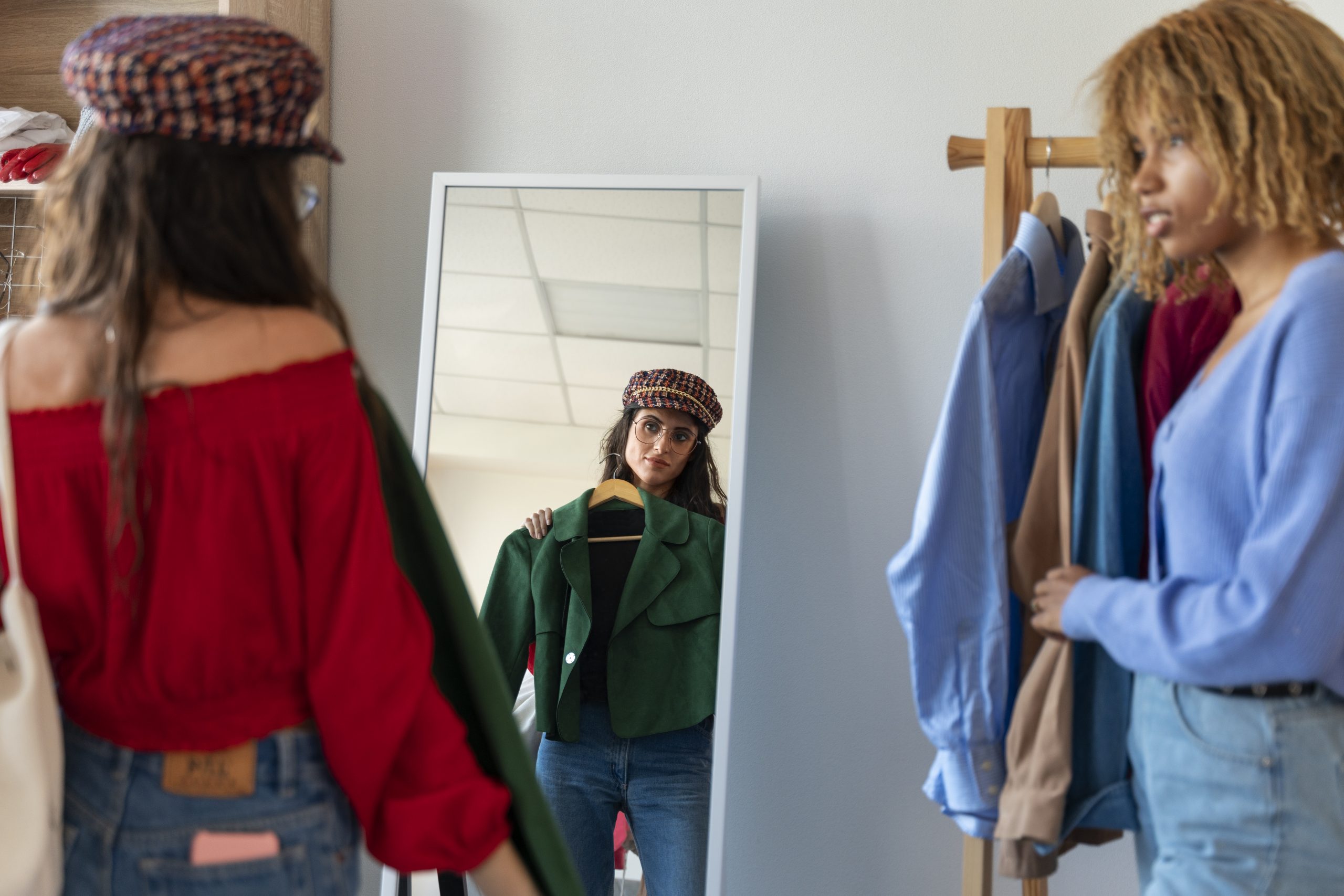 Two girls trying on clothes in front of a mirror