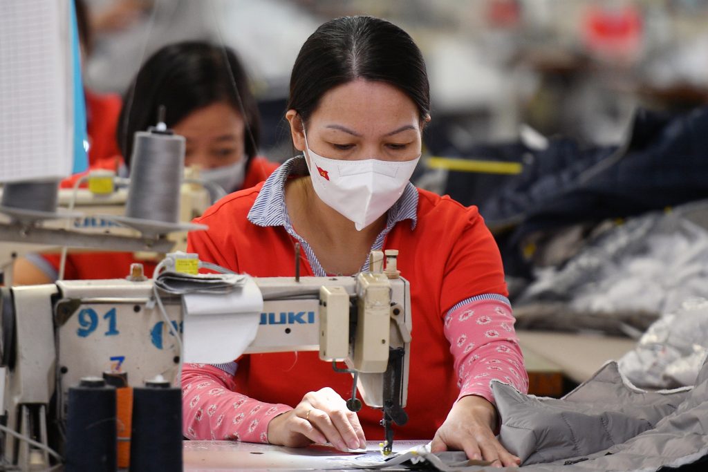 a Vietnamese textile worker sewing a piece of clothes in the apparel company